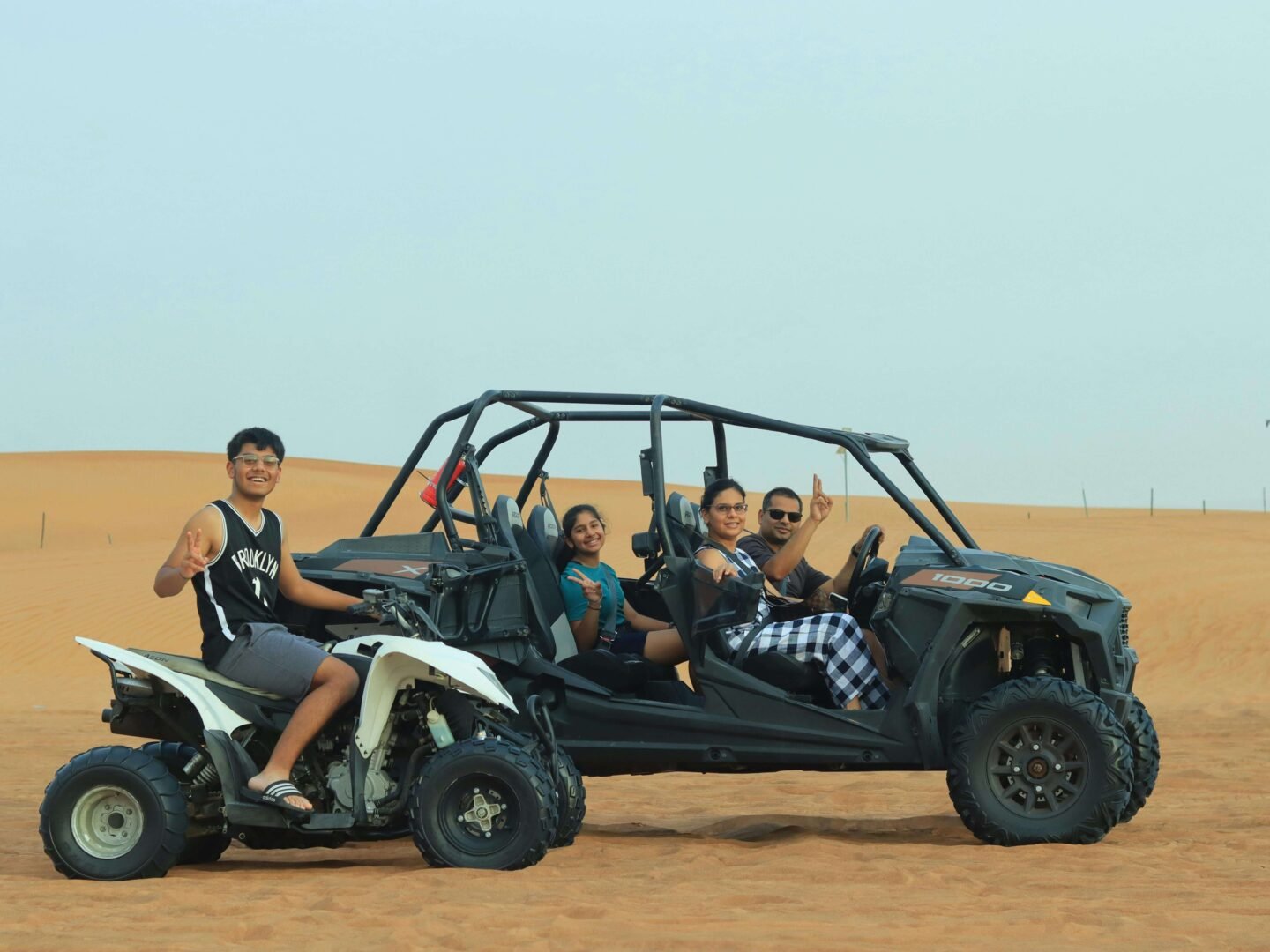 Family driving a 4x4 buggy in the Dubai desert adventure tour